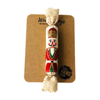 Kézzel készült natúr textil szaloncukor karácsonyfadísz  piros kalapos diótörő mintával, natúr csipkével, barna kraft karton csomagoláson. 