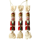 Három kézműves textil szaloncukor karácsonyfadísz piros kalapos diótörő mintával, egymás mellett sorakozva, arany zsinórral.