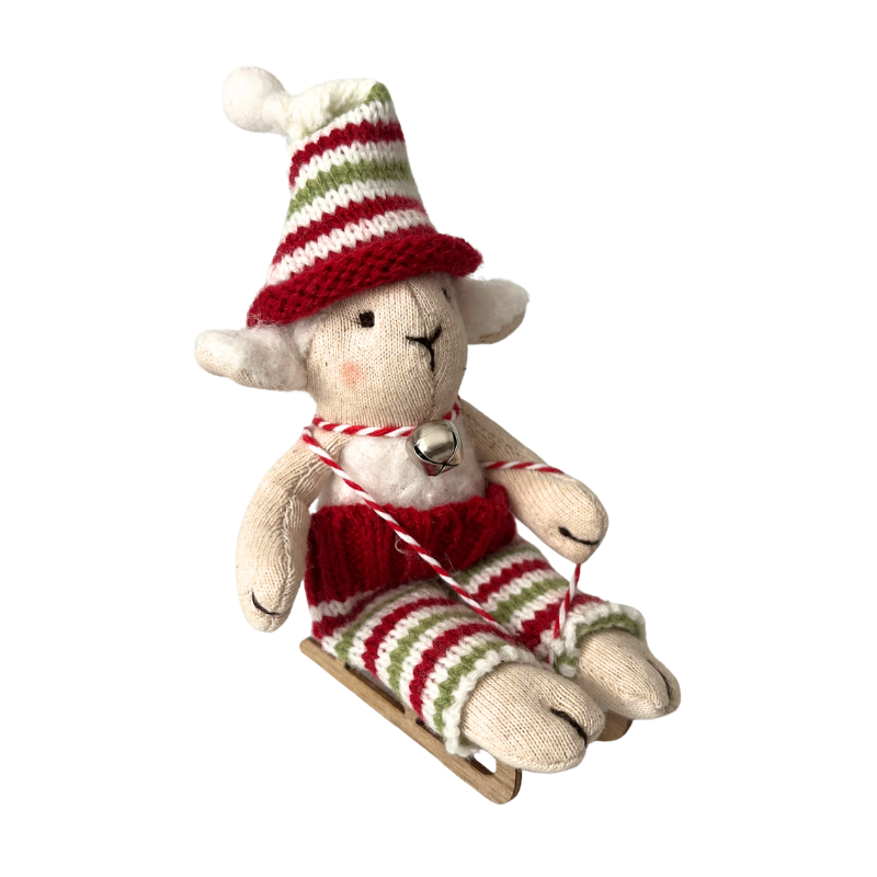 Felhőcske bárány figura mozgatható lábakkal egy fa szánkón ül, karácsonyi ruhaszettben. Tökéletes méretű egy babaházba.