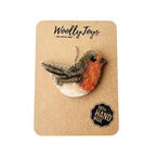 Kézműves tűnemezelt színes gyapjú vörösbegy karácsonyfadísz natúr kraft csomagoláson, részletesen kidolgozott felülettel, fa alapra kasírozva.