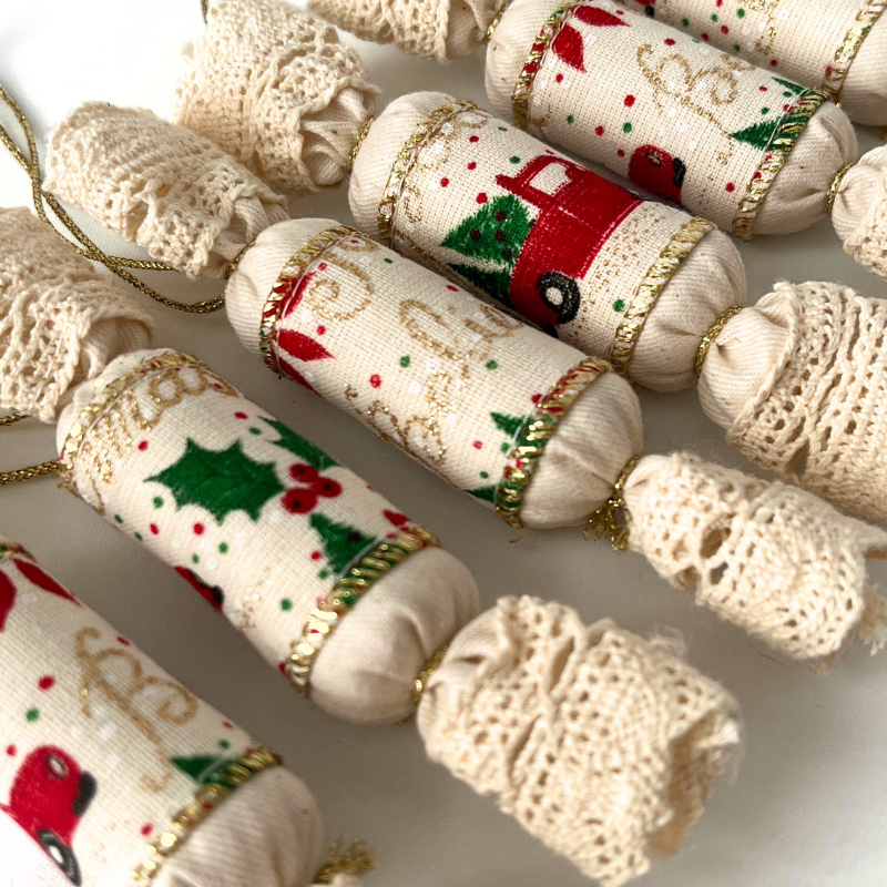 Közeli kép hat darab illatos textil szaloncukor karácsonyfadíszről, változatos autós mintákkal, arany zsinórral, gyapjú töltettel és szegfűszeg illattal.
