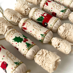 Közeli kép hat darab illatos textil szaloncukor karácsonyfadíszről, változatos autós mintákkal, arany zsinórral, gyapjú töltettel és szegfűszeg illattal.